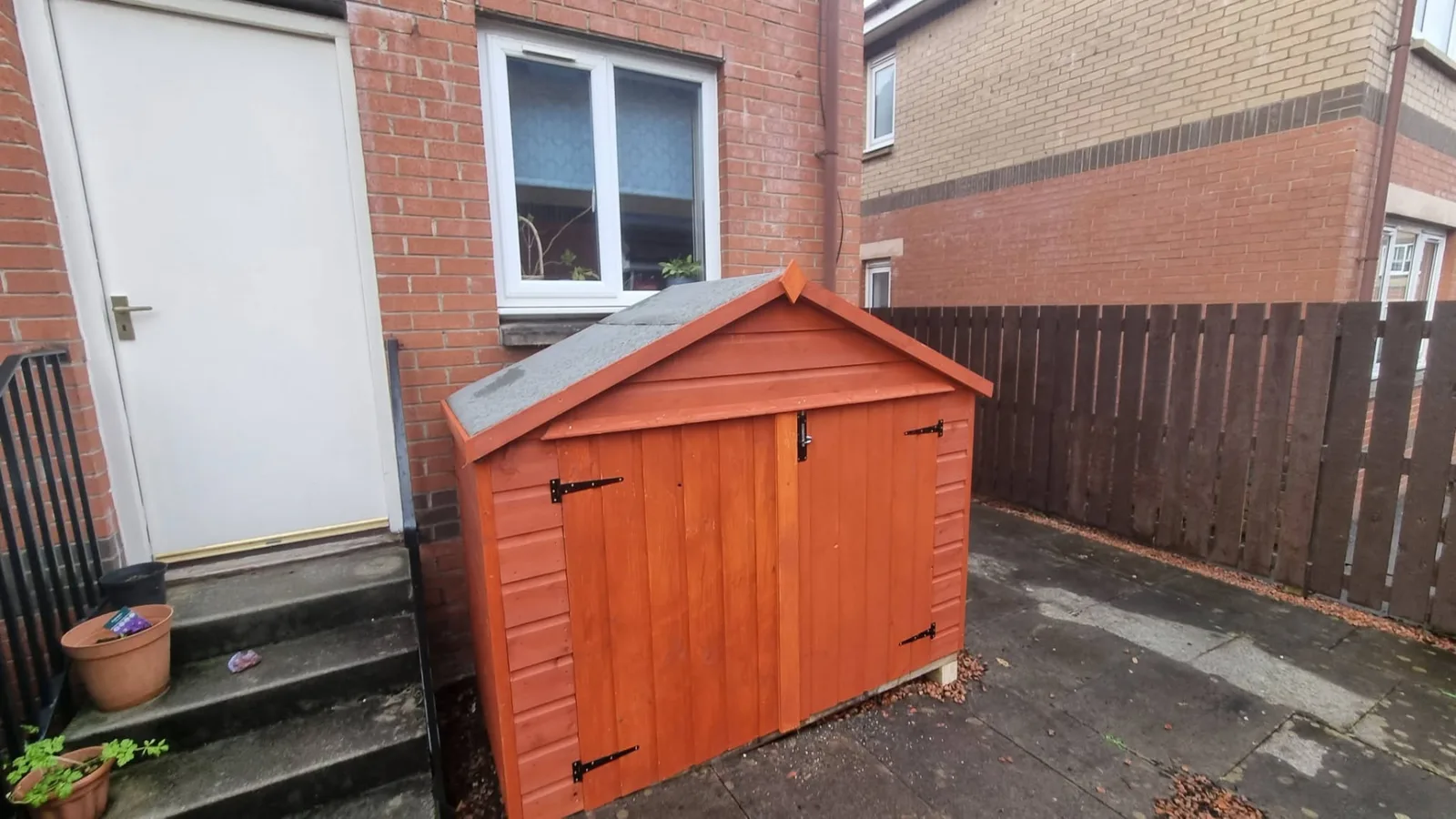 Handmade timber bin store beside a home